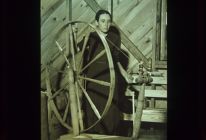 Woman spinning at wheel. Black and white photo. 